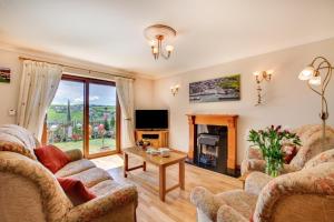 a living room with two couches and a tv at The Buoys in Mawgan Porth