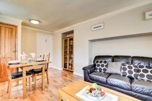 a living room with a leather couch and a table at 4 Pentyre House in Padstow