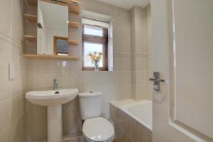 a bathroom with a toilet and a sink and a tub at The Buoys in Mawgan Porth +9 photos