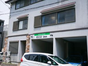 InazawaECO inn的一辆白色汽车停在一栋建筑物前