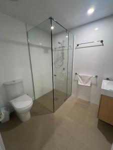 a bathroom with a toilet and a glass shower at Central Located Cozy Studio in South Brisbane in Brisbane