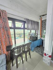 Un comedor con una mesa y una cocina. en Bel's Cozy Suites at Lavernie, en Baguio