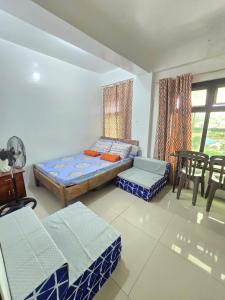 una habitación con una cama, una mesa y sillas en Bel's Cozy Suites at Lavernie, en Baguio