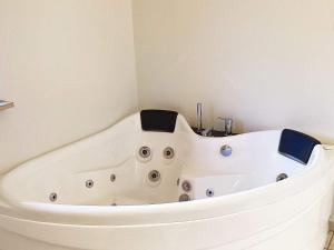 a white bath tub in a corner of a bathroom at 10 person holiday home in Væggerløse-By Traum in Marielyst