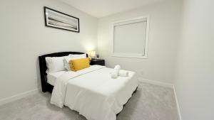 Un dormitorio blanco con dos camas y una ventana. en Casa Koko, en Calgary