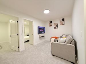 Una sala de estar con un sofá y un televisor. en Casa Koko, en Calgary 17 fotos más