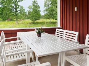 a white table and chairs on a porch with a window at 8 person holiday home in Virestad in Virestad