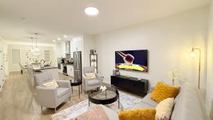 Una sala de estar con un sofá y sillas y una cocina. en Casa Koko, en Calgary