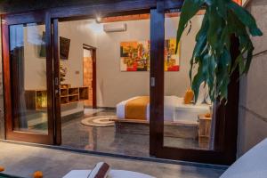 ein Zimmer mit einem Bett und einer Glastür in der Unterkunft Villa Semujan Ubud in Ubud