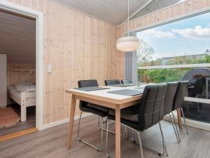 a dining room with a table and black chairs at 6 person holiday home in Bjert-By Traum in Binderup Strand