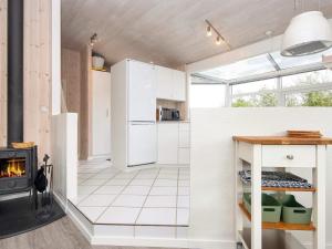 a kitchen with white appliances and a fireplace at 6 person holiday home in Bjert-By Traum in Binderup Strand