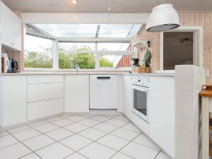 a kitchen with white cabinets and a window at 6 person holiday home in Bjert-By Traum in Binderup Strand