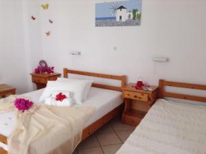 a bedroom with two beds with flowers on them at Arian Hotel in Parikia