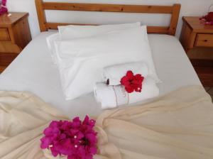 a white bed with towels and flowers on it at Arian Hotel in Parikia