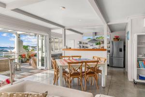 a kitchen and dining room with a table and chairs at Oli Kai - Algies Bay Holiday Home in Matakana