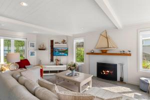 a living room with a couch and a fireplace at Oli Kai - Algies Bay Holiday Home in Matakana
