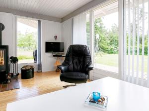 a living room with a black leather chair and a television at 8 person holiday home in Højslev-By Traum in Sundstrup