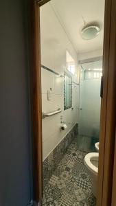 a bathroom with a toilet and a glass shower at Casa en Roldán 2 habitaciones in Roldán +10 photos