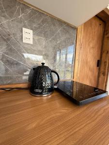 a black tea kettle sitting on top of a table at Refugio lliu lliu, eco suite in Huiscapi