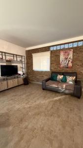 a large living room with a couch and a television at Casa en Roldán 2 habitaciones in Roldán