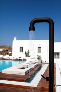 a swimming pool next to a white villa at Amyth of Mykonos Super Paradise in Super Paradise Beach