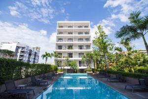 a hotel swimming pool with chairs and a building at Seabreeze Suite 1-Bed T3-637 in Phuket