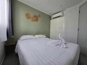 a bedroom with a white bed with a swan on it at Seabreeze Suite 1-Bed T3-637 in Phuket