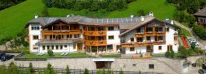 a large house with a solar roof on top of it at Residence Sovara in Santa Cristina in Val Gardena