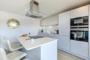 a kitchen with white cabinets and a white counter top at Beach Haven - C6 in Woolacombe