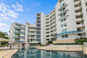 een appartementengebouw met een zwembad ervoor bij Points North Apartments Kings Beach in Caloundra