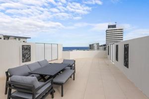 een balkon met een tafel en stoelen op een gebouw bij Points North Apartments Kings Beach in Caloundra