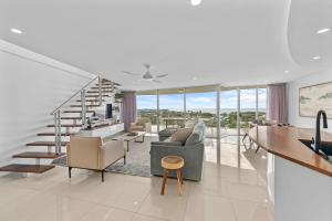 a living room with a staircase and a living room at Beachside Penthouse w Private Rooftop & Oceanviews in Caloundra