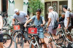a group of people riding bikes down a street at Madam Seven Tam Coc in Vũ Lâm