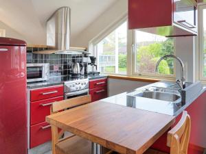 a kitchen with red cabinets and a wooden table at 4 star holiday home in Onsala in Onsala