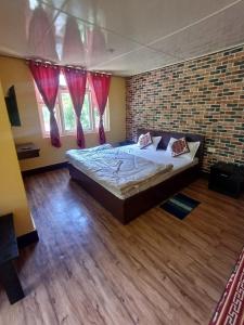 ein Schlafzimmer mit einem großen Bett in einer Ziegelwand in der Unterkunft Zambala Garden Resort in Gangtok