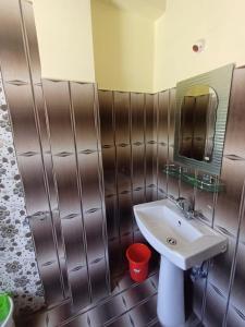 ein Badezimmer mit Waschbecken und Spiegel in der Unterkunft Zambala Garden Resort in Gangtok
