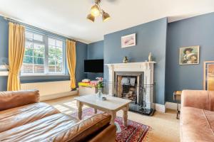 a living room with a couch and a fireplace at The Southend Cottage in Ledbury