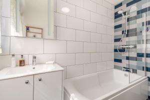 a white bathroom with a tub and a sink at The Southend Cottage in Ledbury +15 photos