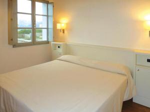 a white bedroom with a bed and a window at Apartment in Elba with Panoramic Views in Rio nellʼElba +16 photos