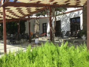 a patio with a wooden pergola and tables and chairs at Asteri Hotel in Livadi