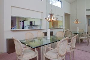 a dining room with a glass table and chairs at Palm Valley Country Club, Pickleball, Tennis, Gym, Clubhouse, Swimming Pools, Lux, Spac 2 Bdrms Den 2 Ba in Palm Desert