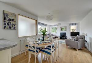Una cocina y una sala de estar con mesa y sillas. en Autumn Leaves, en Ilfracombe