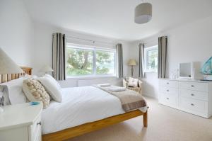 Un dormitorio blanco con una cama grande y una ventana. en Autumn Leaves, en Ilfracombe
