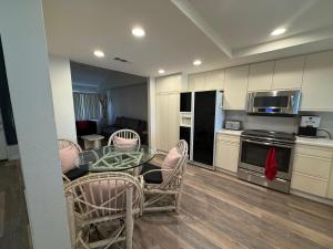 a kitchen with a glass table and chairs in a room at Palm Valley Country Club, Pickleball, Tennis, Gym, Clubhouse, Swimming Pools, Lux, Spac 2 Bdrms Den 2 Ba in Palm Desert