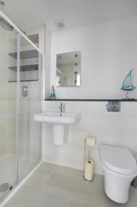 Un baño blanco con inodoro y lavabo. en Autumn Leaves, en Ilfracombe 19 fotos más