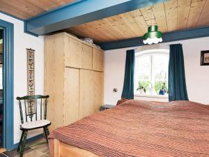 a bedroom with a bed and a chair and a window at 4 person holiday home in Bredebro-By Traum in Ballum