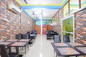 a restaurant with tables and chairs and a brick wall at Hotel O New Orchid Inn in Kolkata
