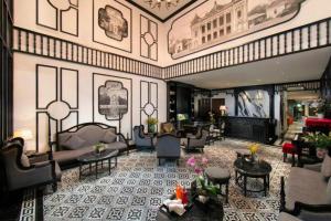 Un vestíbulo con sofás y mesas en un edificio. en Hanoi Le Chateau Hotel & Spa, en Hanói