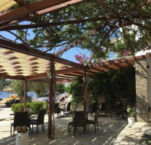 a wooden pergola with chairs and tables on a patio at Asteri Hotel in Livadi