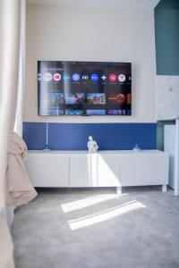 ルーアンにあるArt, confort et lit d'exceptionの壁にテレビが取り付けられたリビングルーム